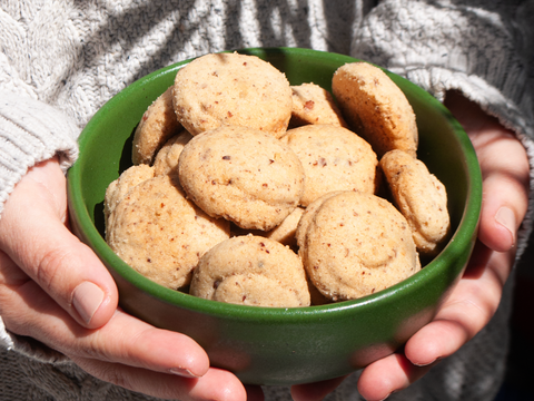 Galleta polvorón pastelerías marisa en gudalajara, suave galleta con nuez en un bowl verde de cerámica sostenido por una muchacha